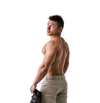 Cute muscular ripped young bodybuilder turning to look at camera. Isolated on white background in studio