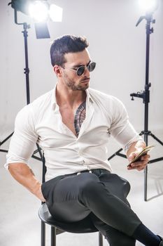 Attractive VIP man in studio with spotlights behind him, being interviewed or taking photographs