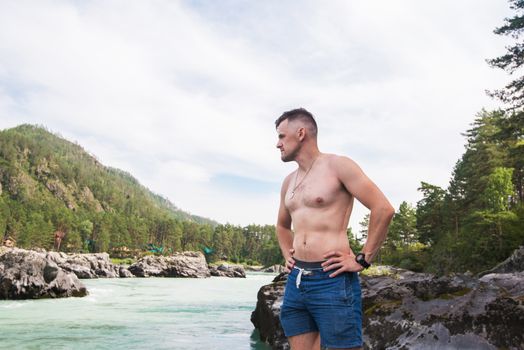 Man resting at river in Altai Mountains territory