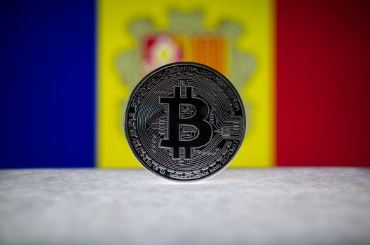 Physical silver version of Bitcoin (BTC) and Andorra Flag on the background. Conceptual image for investors in cryptocurrency and Blockchain Technology.