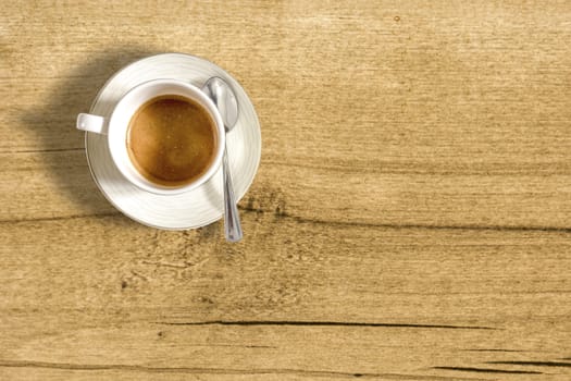 top view of a small cup of coffee on a wooden table. Taking a break with a coffee