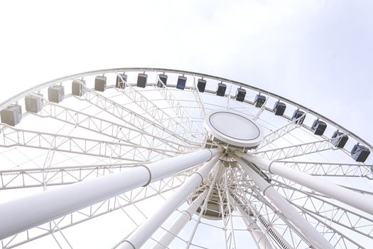 Bottom view of a ferris wheel against a clear sky. Architecture and amusement parks. Fun and tourist attraction