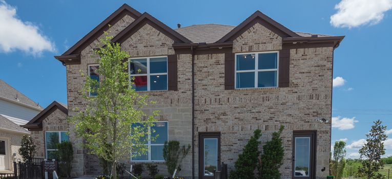 Panorama view two story house with attached garage in new development neighborhood near Dallas, Texas, USA.