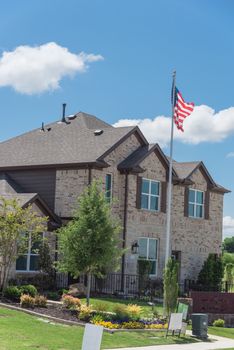 Brand new two story house with attached garage in new development neighborhood near Dallas, Texas, USA. Model house with American flag