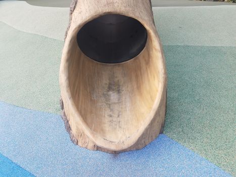 tree log slide on playground with soft blue and green surface or ground