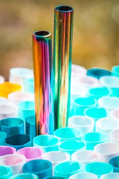 plastic and metal straw on colorful background.