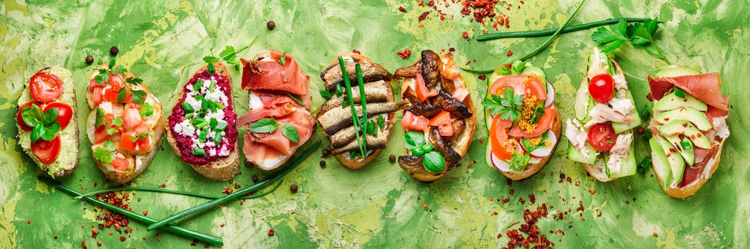 Assorted bruschetta with various toppings.Appetizing bruschetta.Variety of small sandwiches.Mix bruschetta