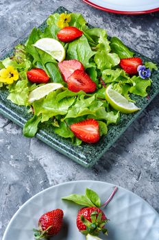 Light salad with greens, strawberries and lime.Summer food