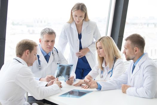 Group of doctors look and discuss x-ray in a clinic or hospital