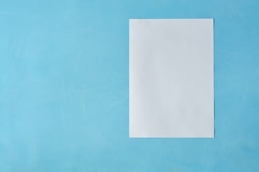 White sheet paper on blue background with copy space for text. Print disign consept.