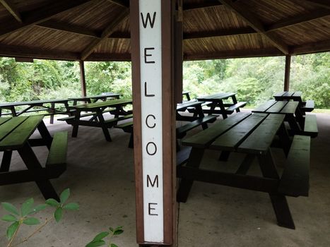 welcome sign on picnic pavilion with tables at park