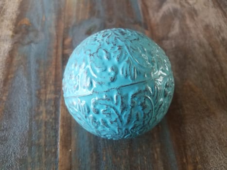 blue metal ball or sphere on brown wooden table