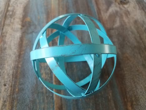 blue metal ball or sphere on brown wooden table