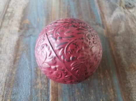 red metal ball or sphere on brown wooden table