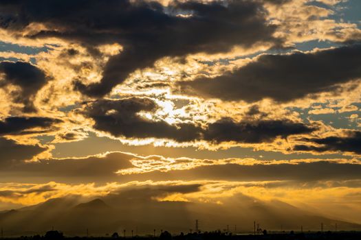 Sunset over mountains with storms clouds