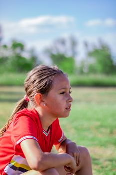 Little girl playing soccer on grassy esplanade