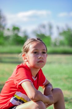 Little girl playing soccer on grassy esplanade