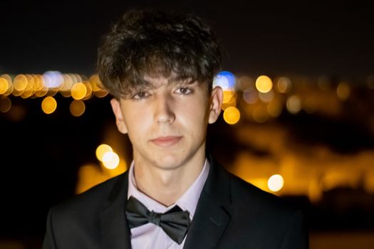 Night portrait of young boy in suit
