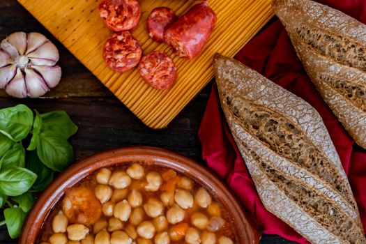 Chickpea dish and ingredients in composition on wooden background
