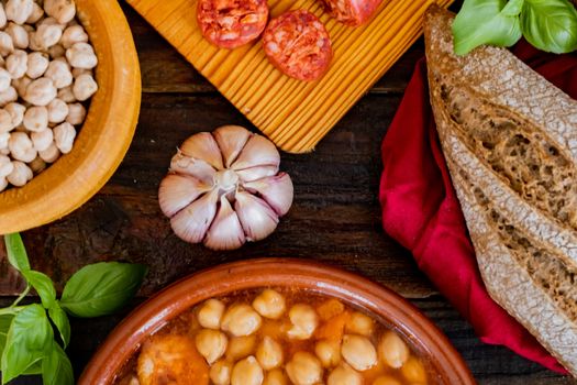 Chickpea dish and ingredients in composition on wooden background