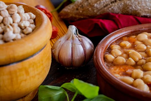 Chickpea dish and ingredients in composition on wooden background