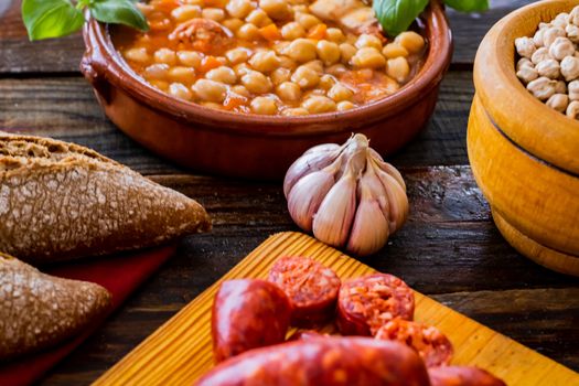 Chickpea dish and ingredients in composition on wooden background