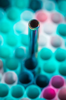 plastic and metal straw on colorful background.