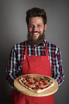 Happy smiling man holding home made heart shaped pizza