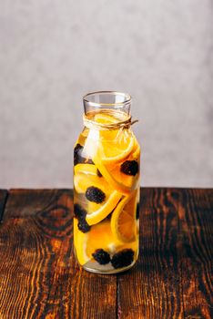 Bottle of Infused Water with Sliced Raw Orange and Fresh Blackberry.