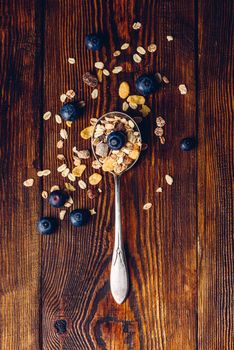 Spoonful of Muesli and Blueberry on Wooden Table. View from Above. Vertical Orientation.