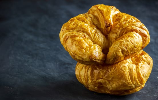 Closeup croissant on table in dark background. Copy space for text.