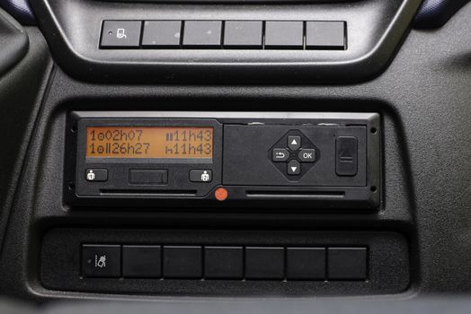 Digital tachograph display shows the 11 hour day break. Starting new shift. No personal data. Tachograph in a van.