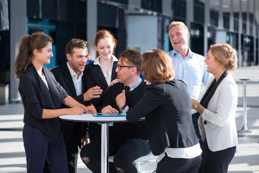 Group of happy business people congratulating their successful coworker
