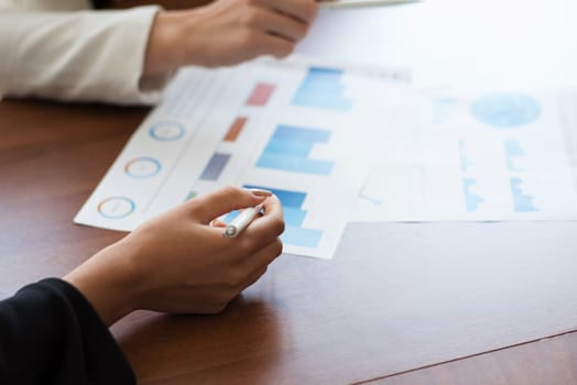 Business people pointing at diagrams discussing financial reports at workplace