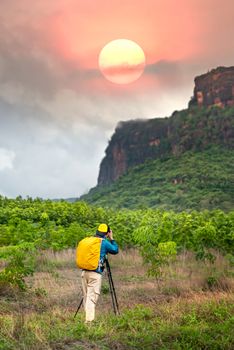 back view photo of man backpacker taking photos