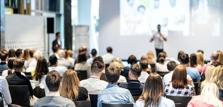 Audience at the conference hall. Male speaker giving a talk in conference hall at business event. Business and Entrepreneurship concept. Focus on unrecognizable people in audience.