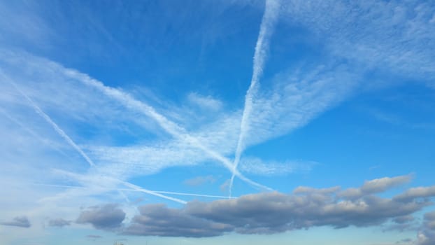 View from bottom on the white clouds on the blue sky background.