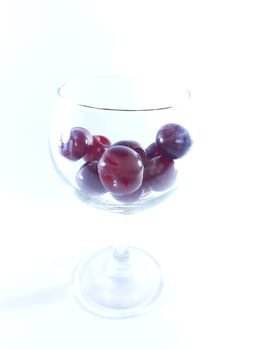 Cherry fruit in transparent wineglass. Cherry for a snack. Photo isolated.