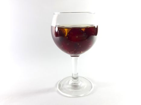 Drink with fruit in transparent glass. Cherry for a snack. Liquid in a glass. Photo isolated.
