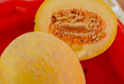 Cut ripe melons on red tray on the table close-up