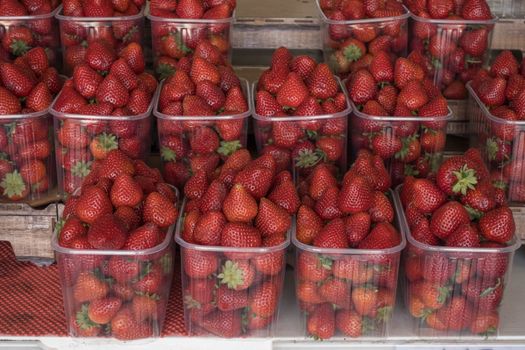 Big baskets of red ripe strawberries for sale in the street shop.