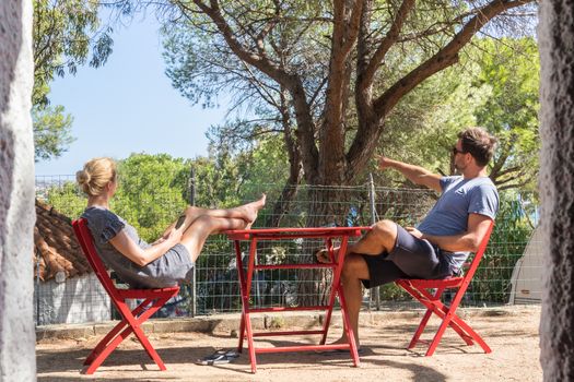 Couple on vacations resting and enjoing in front of mobile home house at camping site in pure nature. Family vacation travel, holiday trip Sardigna, Italy.