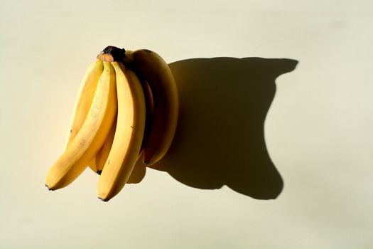 Bunch of bananas. Ripe bunch of bananas. Lonely fruit on a light background. Hard daylight.