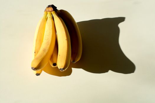 Bunch of bananas. Ripe bunch of bananas. Lonely fruit on a light background. Hard daylight.