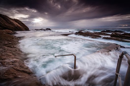 Rough seas after a storm had large waves crashing over and into the rock pool and swift overflows rushing every which way from both sides