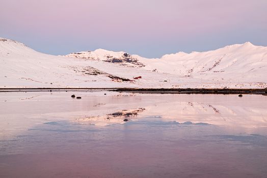 Mountains in Snaefellsnes peninsula reflected in the water at sunset in winter, Iceland