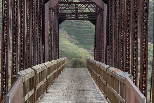 walking through a metal bridge with a wooden walkway