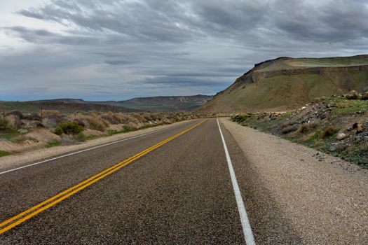 road near sunset with some darker clouds settling in