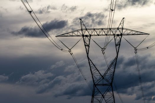 sky based shot of a power distribution tower with dark clouds in the background