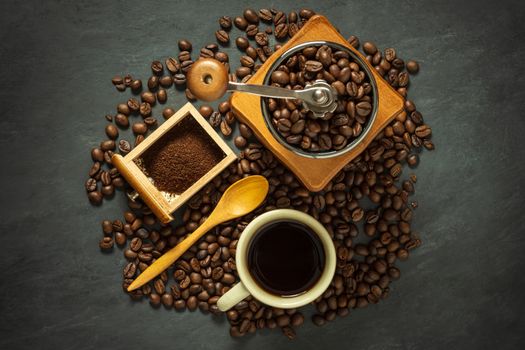 Coffee cup and coffee equipment on black cement floor. Top view and copy space for text.